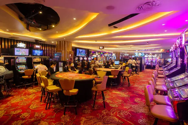 A young woman relaxing with her phone while dynamic casino elements float around her, illustrating the smooth mobile experience offered by the LUCKYBANGLA88 app.